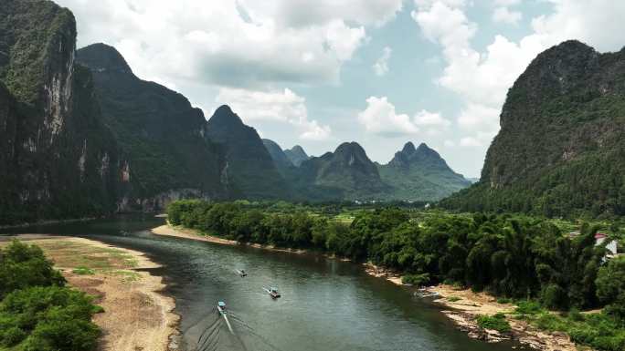 蓝天白云下桂林喀斯特峡谷漓江水面上的竹筏