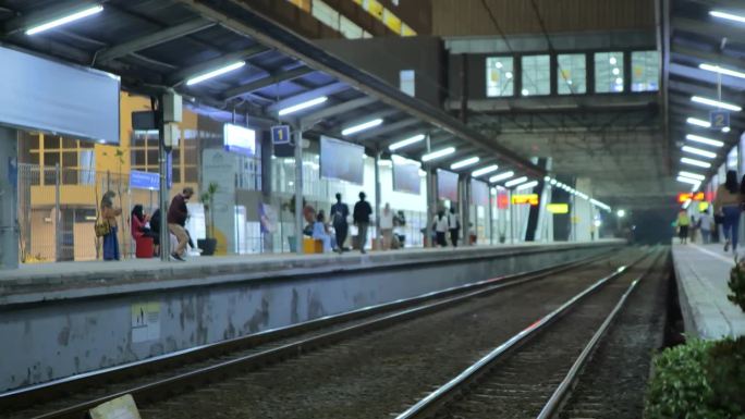 深夜时分，雅加达一个通勤火车站空荡荡的，乘客们正步行回家。描述工作活动到深夜