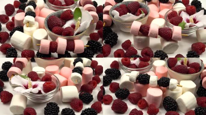 小碗里放着锦葵树、覆盆子、黑莓和蓝莓的花，在白色的桌子上放着浆果串和棉花糖，野餐和聚会。
