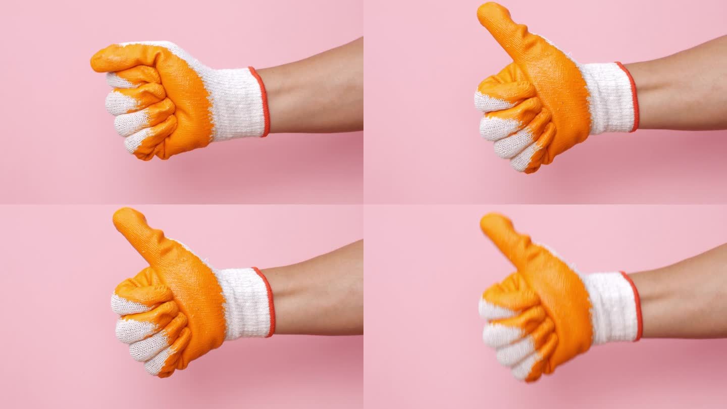 橙色的机械手套在粉红色的背景上做了一个很棒的大拇指标志。