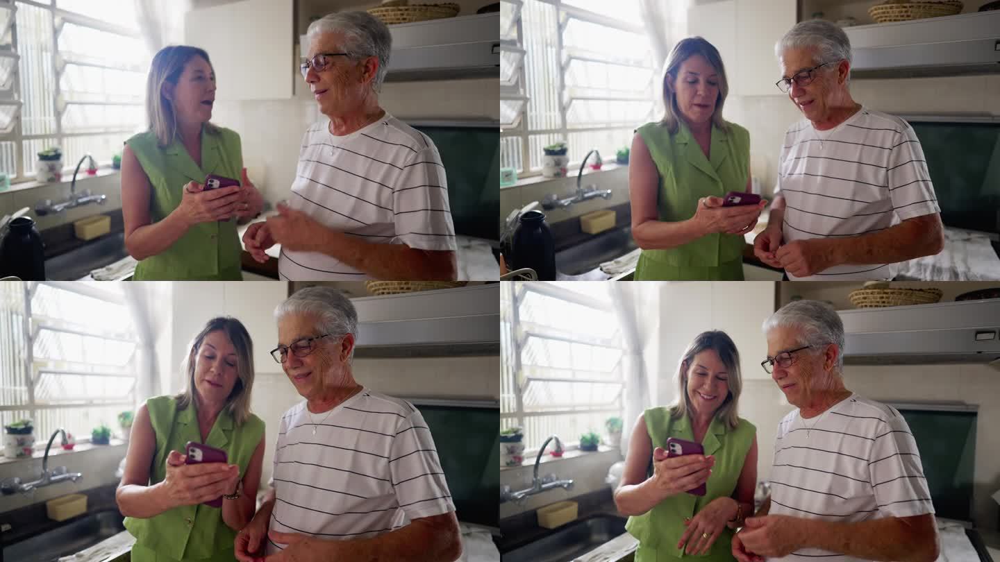 老夫妇在厨房一起看手机。妻子向丈夫展示画面，真实生活中的大笑和微笑