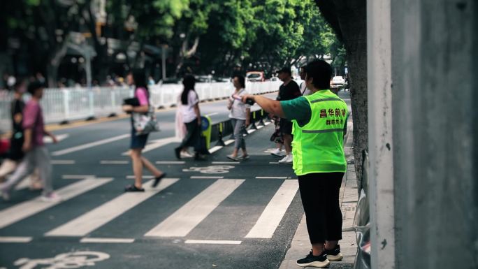 志愿者指挥交通疏导行人街边红绿灯安全