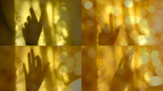 女性手的模糊阴影在黄色墙壁背景与线条花卉图案，金色闪光散景。抽象，漏光漏影，自然光。大气的心情，舞蹈