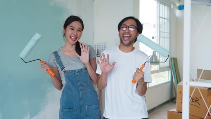 幸福休闲放松亚洲夫妇装修客厅和舞蹈一起装修工具。公寓装修和房屋装修的同时进行。装修家居