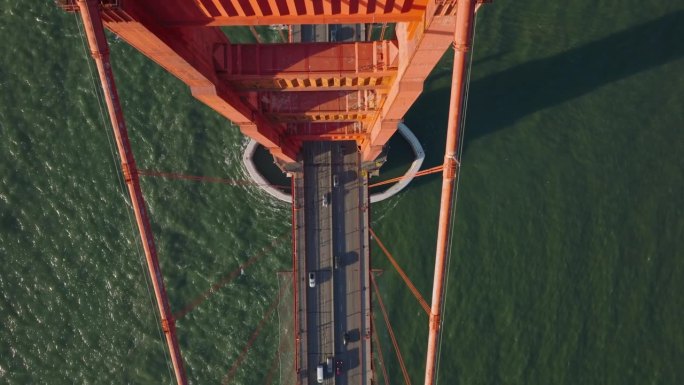 大桥上的繁忙道路的高角度视角，横跨海峡的波纹水。黄金时间的金门大桥迷人景色。美国加州旧金山