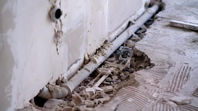 浴室地板破洞附近的墙和排水管道破旧