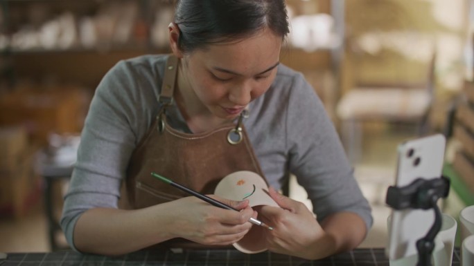 年轻女子在她的陶器作坊里制作手工陶瓷，小生意的概念