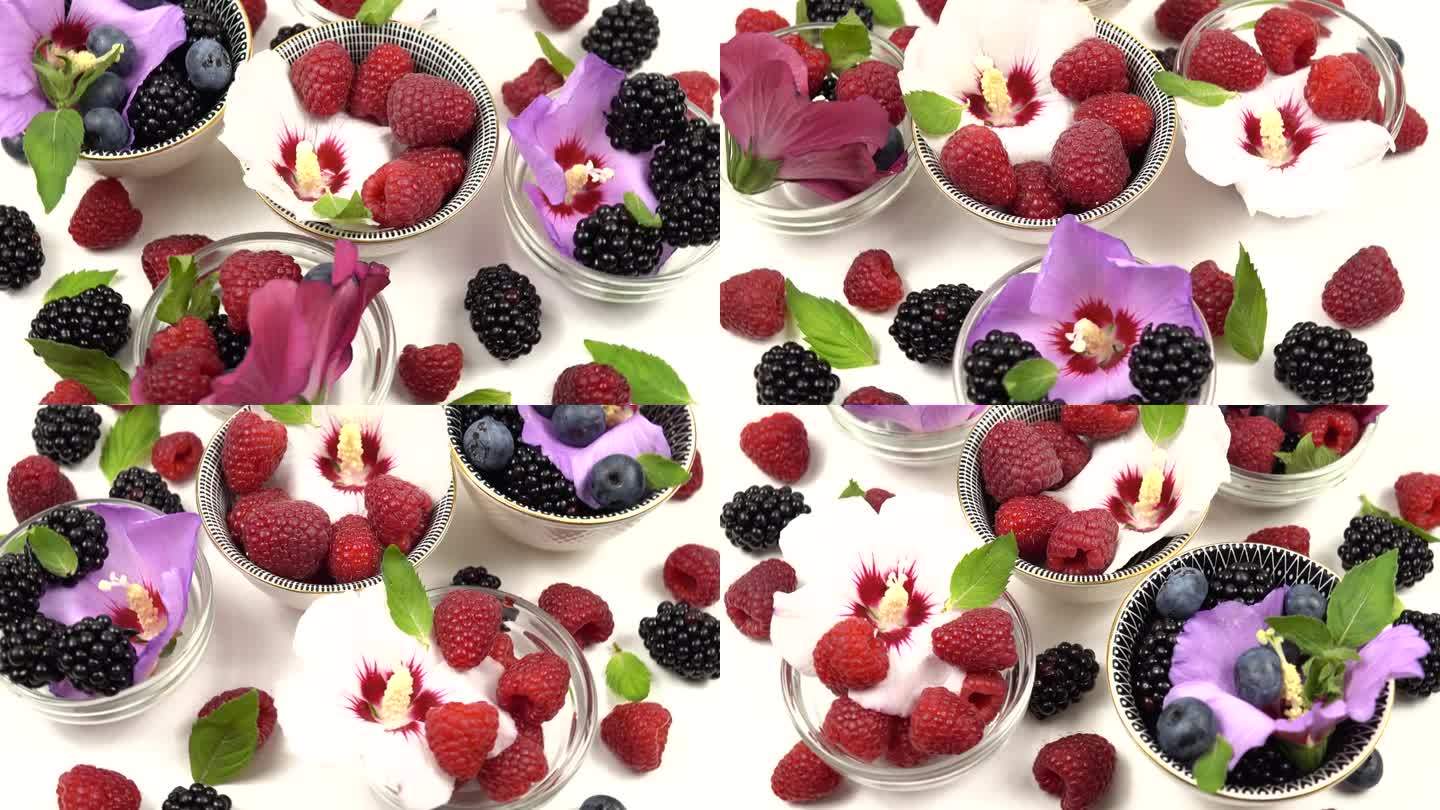 白色桌子上的小碗里放着锦葵树、覆盆子、黑莓和蓝莓的花