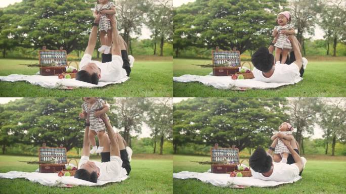 年轻的父亲和他的小女儿在公园里玩得很开心