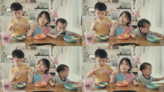 积极情绪:快乐的亚洲兄弟姐妹兄弟姐妹一起吃薯条。
