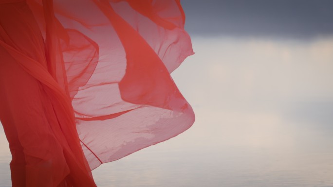 一个身穿红色长裙的女人站在湖中红裙