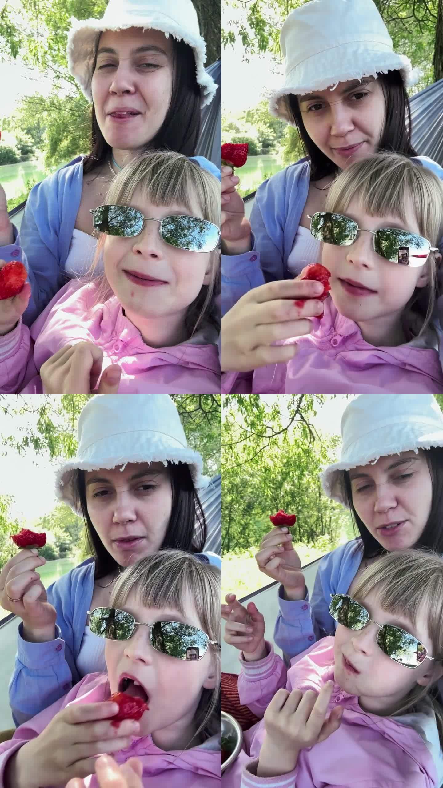 母亲和女儿在吊床上吃草莓