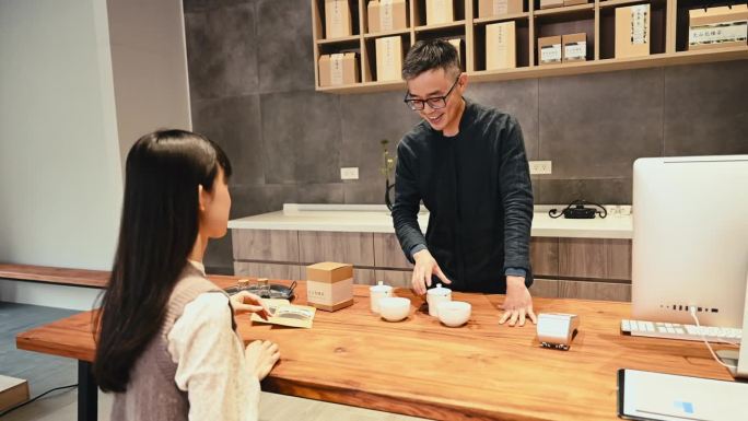 茶品牌老板经营着他的小生意，在茶道上向他的顾客介绍和供应中国茶。