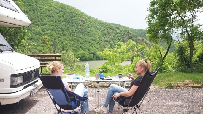 美丽的湖景和嬉皮女性享受咖啡和愉快的交谈
