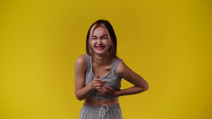 一个女孩在黄色背景上为视频摆姿势的4k视频。