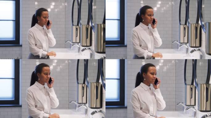 非裔美国女学生站在校厕所讲手机