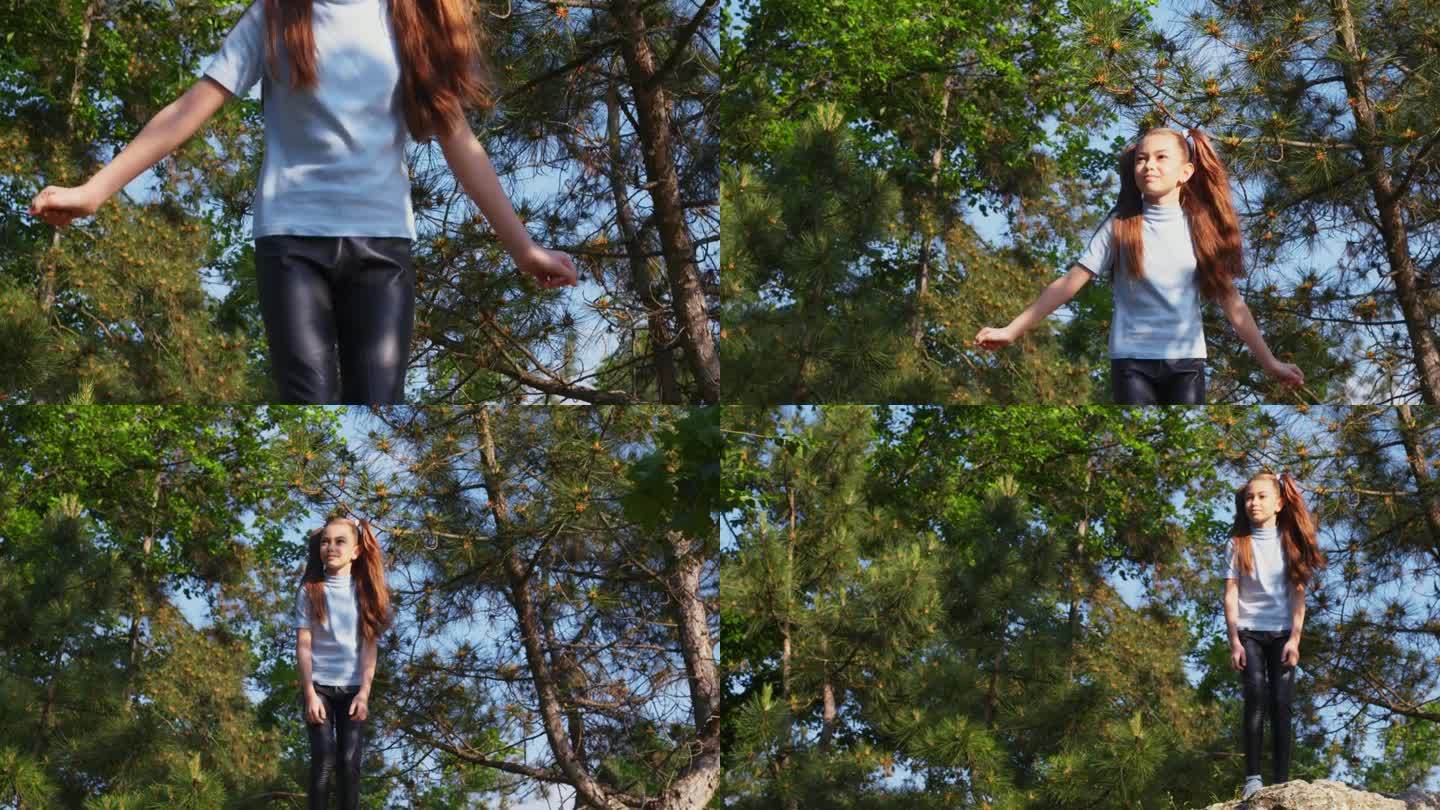 小女孩站在森林里的一块石头上，享受大自然