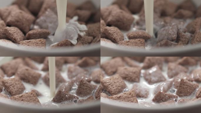 慢镜头特写:早餐用麦片巧克力枕头把牛奶倒进碗里
