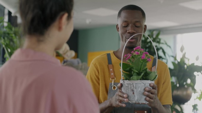 非洲裔美国推销员与女性客户谈论花店中盛开的植物