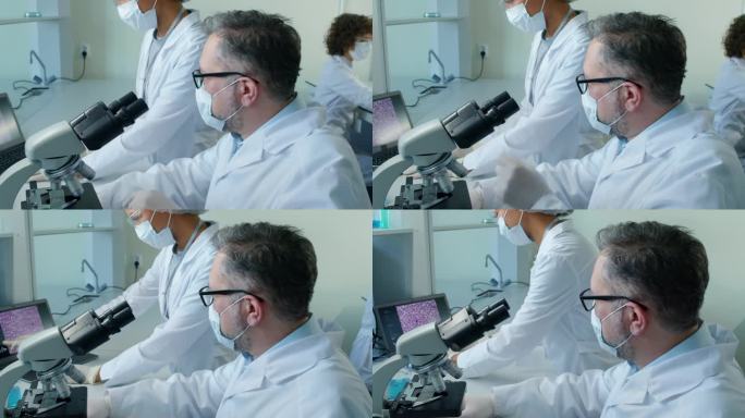 资深男科学家在显微镜下观察