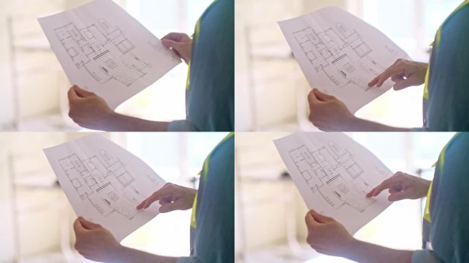 专业建筑师的手指着手里的公寓设计方案图纸
