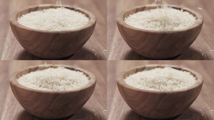 慢镜头的印度香米掉进木桌上的碗里