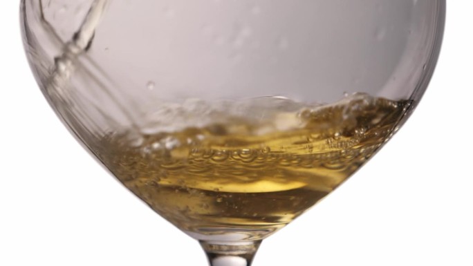 把白葡萄酒倒进玻璃杯。品尝奢侈的饮料。慢动作