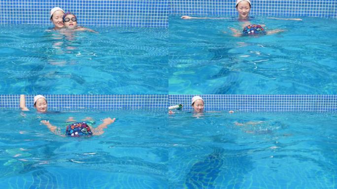小男孩和妈妈在游泳池游泳妈妈鼓励孩子