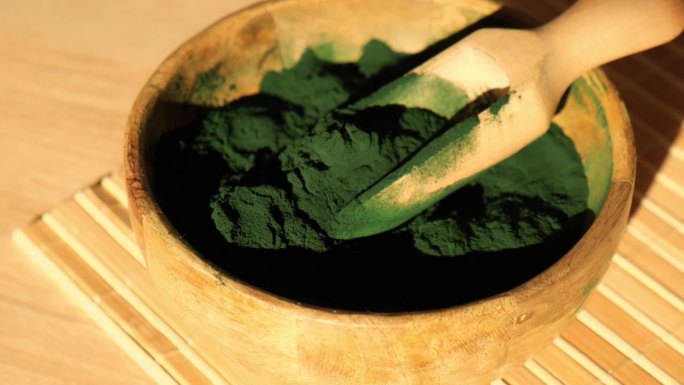 竹生态碗中的蓝绿藻、小球藻和螺旋藻粉。超级粉匙。排毒超级食品。藻类的天然补充