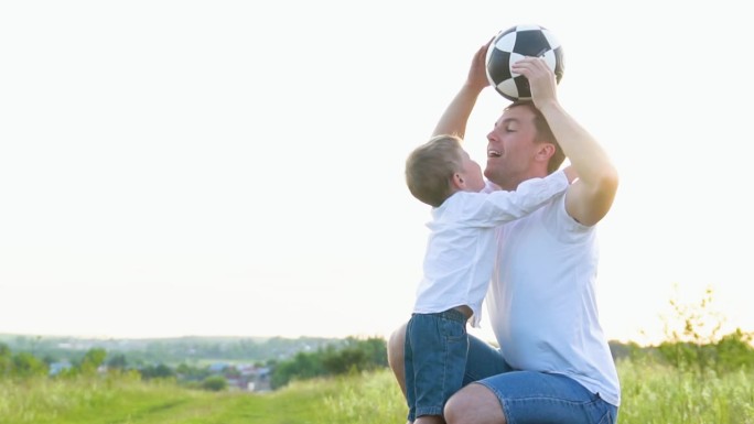 快乐的父亲和他的儿子在操场上玩球