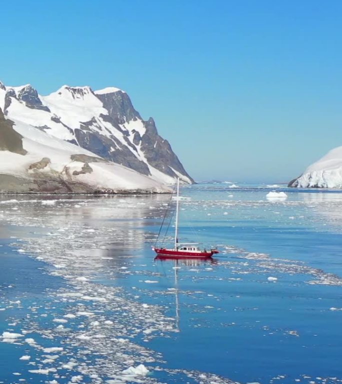 垂直视频南极海洋的雪山和孤独的船。