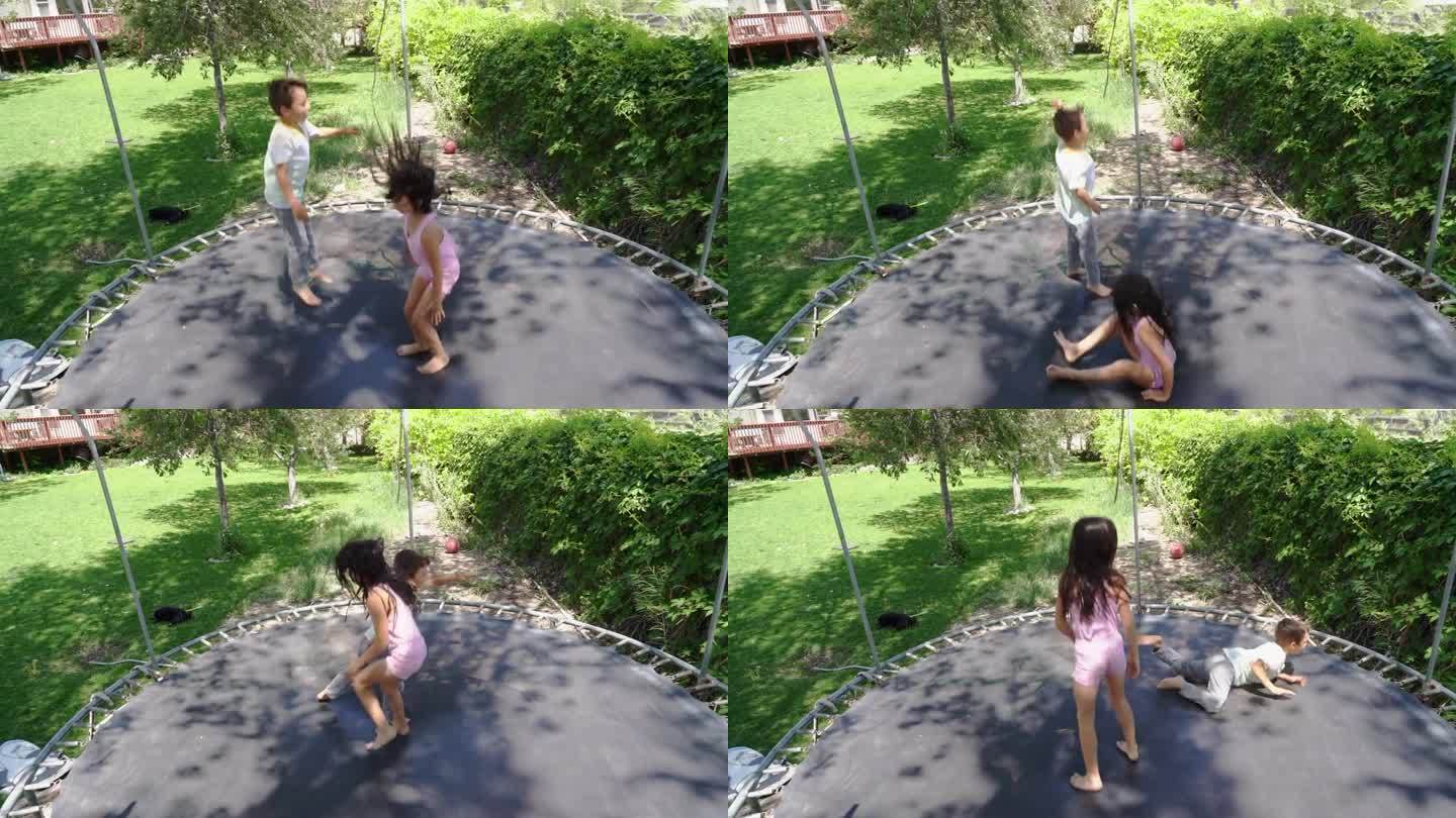 在一个绿色的院子里，蹦床活跃起来，一个6岁的小女孩和一个5岁的小男孩在蹦床上跳着，咯咯地笑着。院子里
