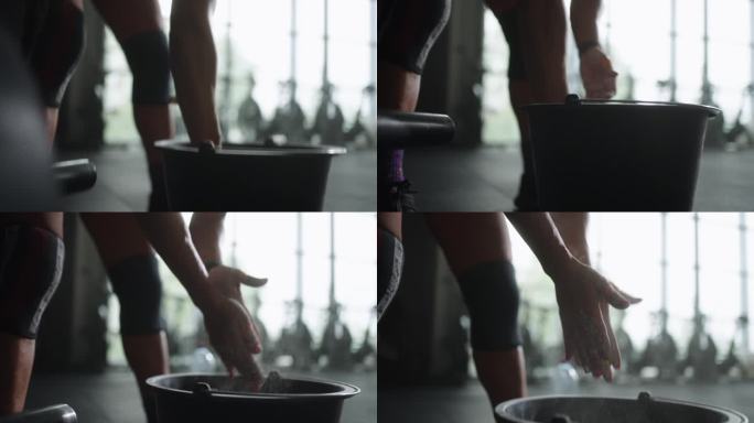 职业举重女运动员在健身房的身体视图，女运动员在手掌上服用镁粉