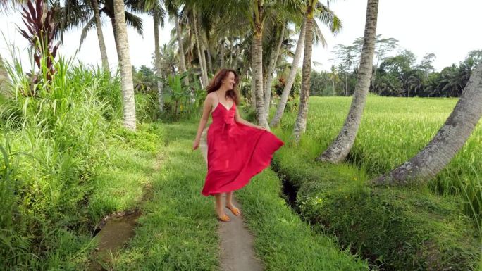 她欢快地沿着小路跑着，她的红裙子在风中飘动，慢动作
