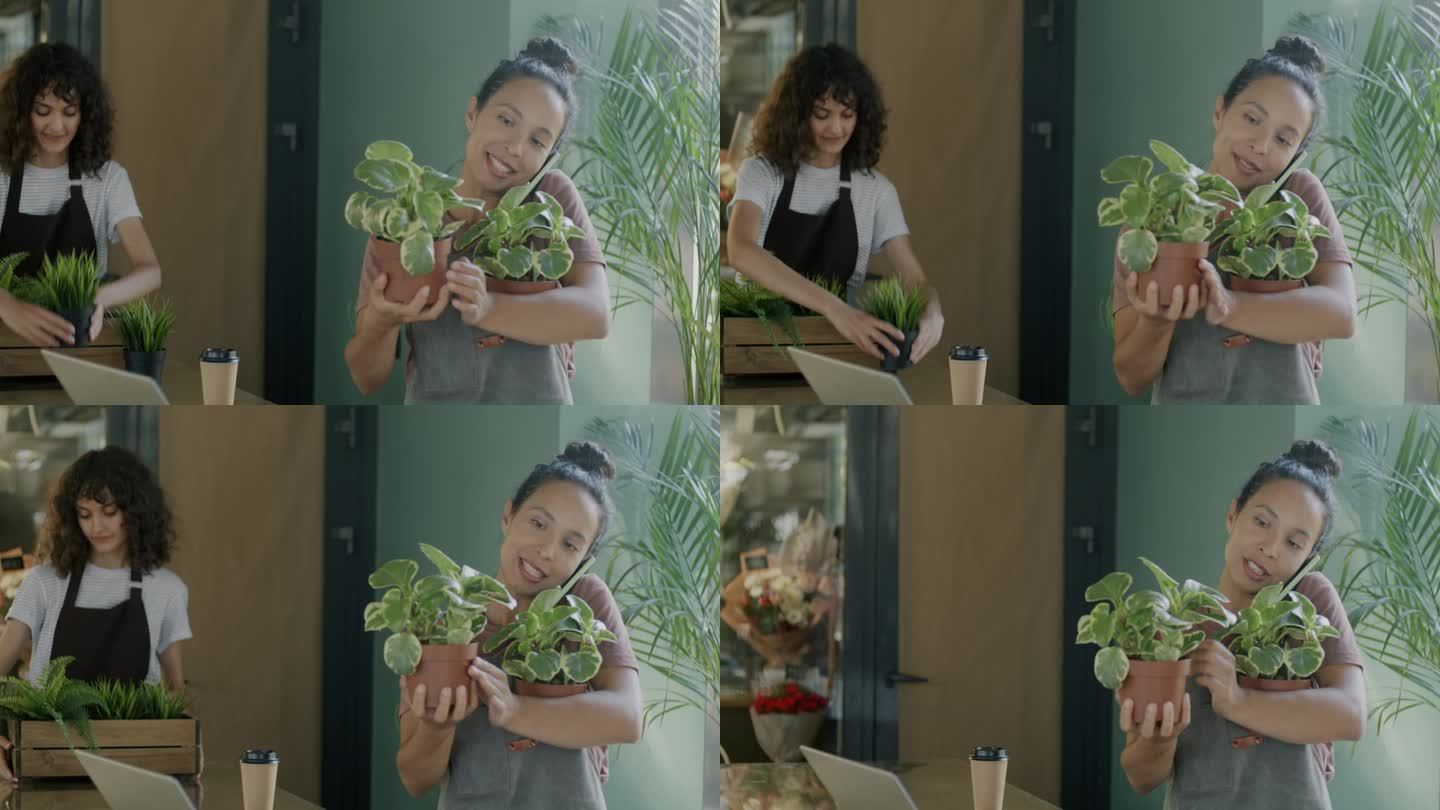 年轻的中东妇女在花店拿着盆栽植物，用手机接客户的订单