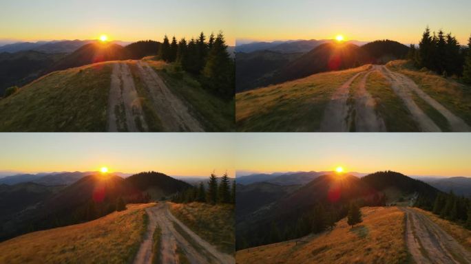 跨越山顶的越野路。黑暗的土路被明亮的夕阳照亮。在野生山林中令人惊叹的日落景色。美丽的自然景观