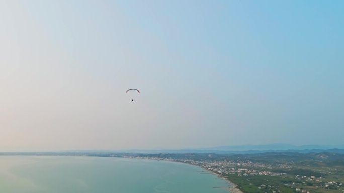日落时的动力滑翔伞，俯瞰海洋