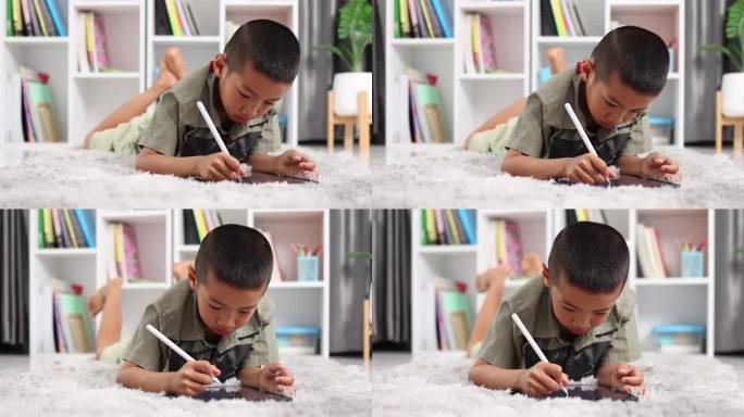 小男孩喜欢在电脑平板屏幕上用触控笔学习写字或美术绘画，带着做作业或回到学校的人在家里的pad上学习。