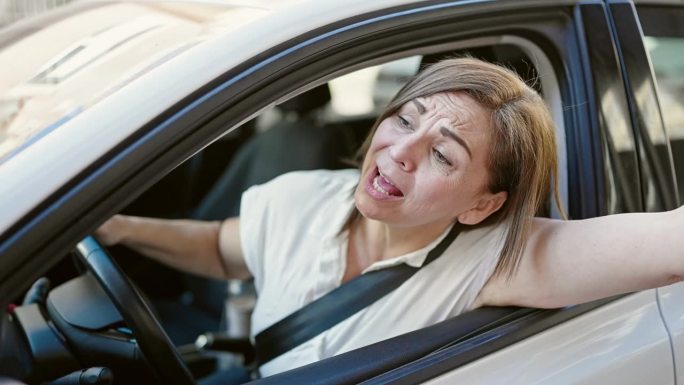 中年西班牙妇女在街上开车很紧张