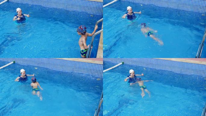 小男孩和妈妈在游泳池游泳妈妈鼓励孩子