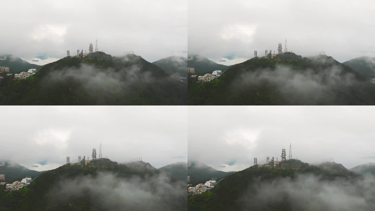 在雾蒙蒙的日出时，电信塔在山上的鸟瞰图。