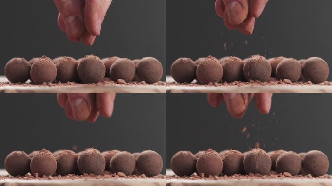 慢镜头特写:一个人在巧克力松露上撒可可粉