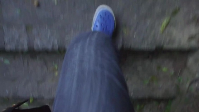 穿着蓝洞洞鞋走上鹅卵石楼梯-向前滑动。