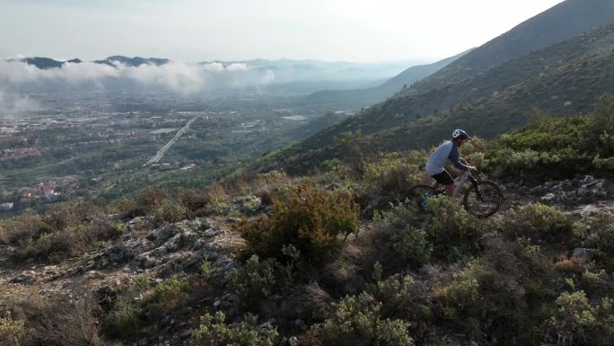 资深男性山地自行车手穿越崎岖的山脊