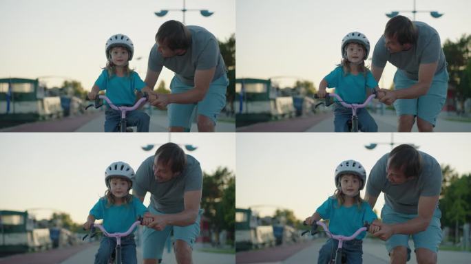 爸爸教女儿骑自行车。幸福家庭的童年梦想概念。爸爸和小女儿在公园里学骑自行车。幸福的家庭喜欢户外运动，