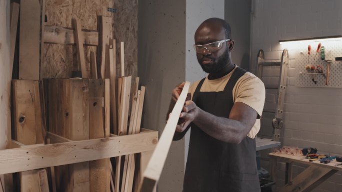 木工在准备工艺时握住木板并估计尺寸