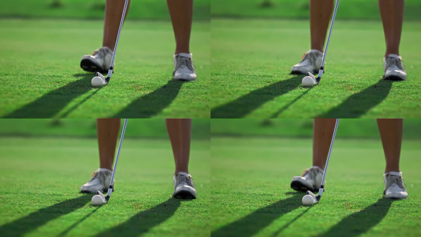 高尔夫球员的双腿站在高尔夫球场的草地上。女子在室外挥杆高尔夫球