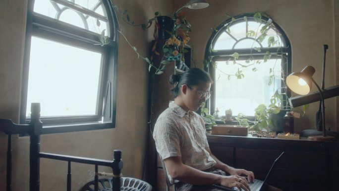 亚洲年轻人在古董店里摆弄笔记本电脑