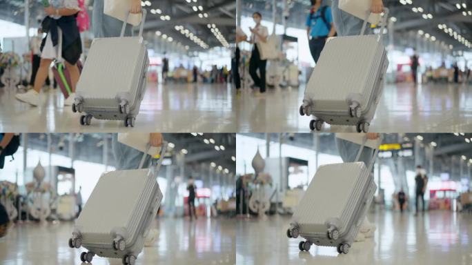拖着行李箱走向机场登机口的女旅客