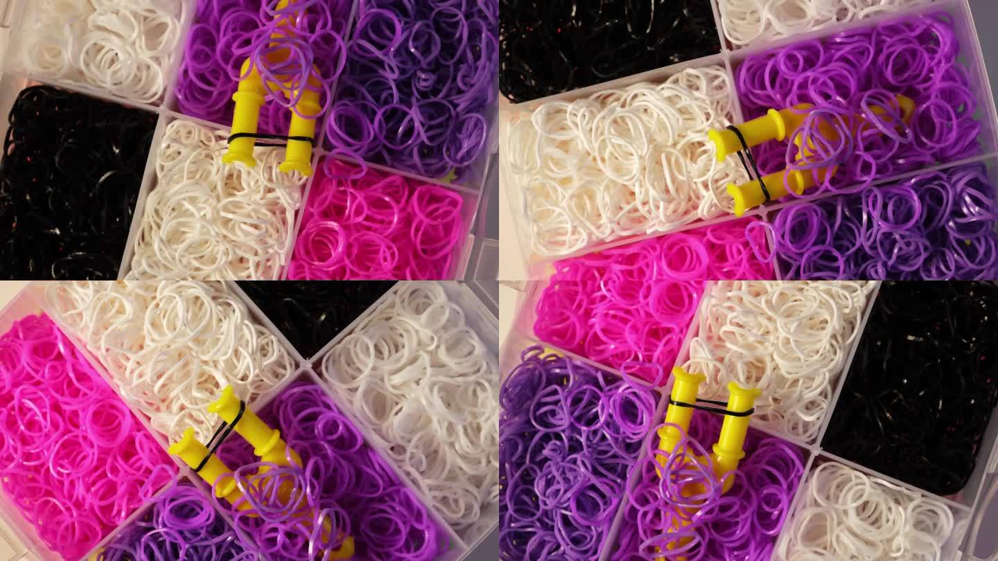 织布机带套件各种颜色，钩针钩和夹子在塑料盒，俯视图。橡皮筋填充织机套装。孩子手链制作工具包。4K视频